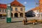 Wooden sculpture of Czech writer Bohumil Hrabal, bench with a cat, Premyslid Square and Hlav`s house in sunny autumn day, Nymburk