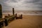 Wooden sea defences on the sandy beach on the Norfolk Coast