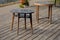 Wooden seating area with benches lined with natural wood by the water. terrace by the pond with a picnic bench and old round table