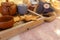 Wooden serving tray with brown ceramic kettle, steaming hot drink mug in a cozy home interior. Food, drinks, toy, gingerbread