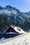 Wooden shack in the mountains covered with snow.