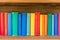 wooden shelf with row of colorful childrens books