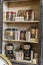 Wooden Shelf of a Shop with Ceramic Vases, Glass Containers and Books