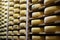 Wooden shelves with alignment of aging cheese Comte wheels, France