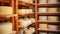 Wooden shelves in basement, cellar with round cheese. Home production