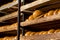 Wooden shelves with fresh golden bread loaves.