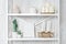 Wooden shelving unit with decor near grey wall. Bookcase with photo frame mockup and candles, living room interior details