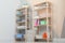 Wooden shelving units with clean towels and detergents in stylish room