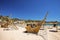 Wooden shipwreck decoration on seashore at beach against blue sky during summer