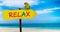 Wooden sign on beautiful beach and clear sea wit text relax. A green parrot sits on a pointer to a tropical paradise