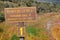 Wooden sign showing the Paseo de la Isla walking trail in Tierra del Fuego National Park, surrounded by green, brown and