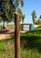 Wooden signpost with a bicycle symbol indicating the moving direction for cyclists along a trail in summer green nature park