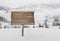 Wooden signpost with snow and mountains