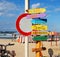 Wooden signpost on sunny beach. Seascape with lovely blue sky