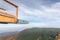 Wooden sky walk top point with view to landscape during a strong wind in the background with moving trees inside forest and hills