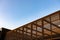 Wooden slat shading structure with roof against sky