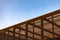 Wooden slat shading structure with roof against sky