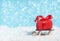 Wooden sleigh delivering Christmas or New Year red present box on blue snowed background