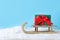 Wooden sleigh with gift box on pile on snow. Space for text