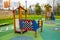 A wooden slide and a canopy with toys on the playground in kindergarten on a clear sunny day.