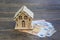 A wooden small house stands on euro banknotes 50, 20, 10. The concept of wealth, purchase, sale, rental of real estate