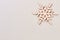 Wooden snowflake on winter paper background.