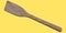 Wooden solid turner or kitchen utensils on yellow background.