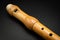 A wooden soprano recorder lying on black background