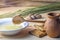 Wooden spoon in a bowl of honey, a clay pot on a wooden table