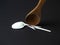 Wooden spoon breaks a plastic disposable spoon on a black background. Without plastic concept