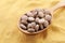 Wooden spoon of brewer`s yeast tablets on powder, closeup