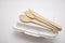 Wooden spoon and fork with knives and bagasse food box , disposable tableware on white background. Eco-friendly materials