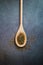 Wooden spoon with fresh oregano on concrete table. Seasoning product. Vertical picture. Top view
