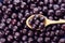 Wooden spoon and fresh ripe acai berries as background