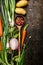 Wooden spoon and fresh vegetables ingredients for cooking on dark background