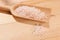 Wooden spoon full of stone salt on a table