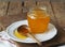 Wooden spoon with a jar of natural rustic honey from a private apiary on a plate.The concept of the health benefits of honey