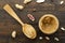 Wooden spoon with a jar of peanut butter and a bunch of scattered nuts