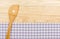 Wooden spoon on a purple checkered table cloth