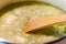 Wooden Spoon Stirring Hearty Green Creamy Soup