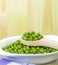 A wooden spoonful of fresh green peas