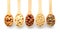 Wooden spoons with different nuts on white background