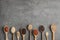 Wooden spoons with different types of quinoa and space for text on grey background