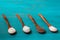 Wooden spoons with different types of salt, black, pink, flake and seasoned with truffle, on a blue wooden background