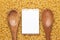 Wooden spoons on dry uncooked macaroni background