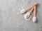 Wooden spoons with stevia pills, powdered and white sugar on grey table