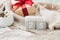 Wooden square calendar cubes with the date December 25 on beige cozy crumpled blanket, gift with red ribbon and sparkling garland