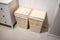 Wooden squared laundry baskets with linen standing against white