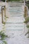 Wooden staircase covered by beach sand on tropical summer