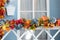 wooden staircase railings decorated Fall yellow leaves, twigs and pumpkins. Entrance of house door decorated fall for holiday.